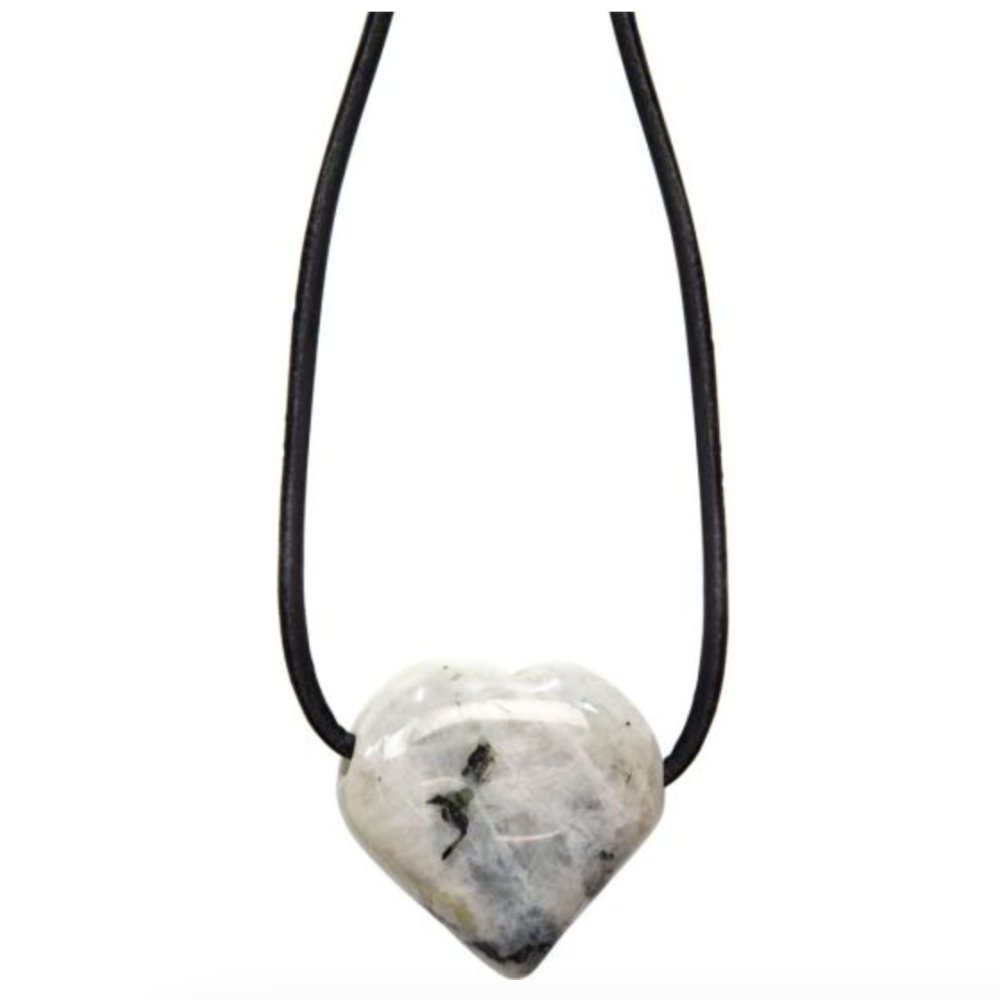Heart-shaped rainbow moonstone necklace on black cord, glowing with soft white and iridescent flashes, symbolizing intuition and new beginnings.