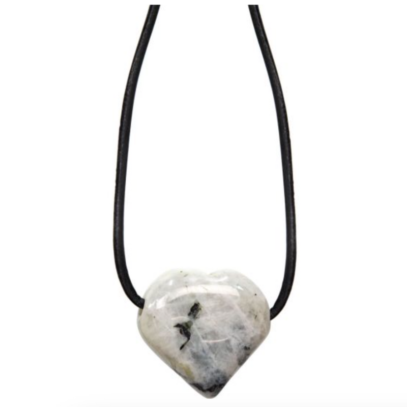 Heart-shaped rainbow moonstone necklace on black cord, glowing with soft white and iridescent flashes, symbolizing intuition and new beginnings.