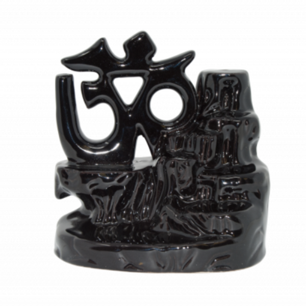 Glossy ceramic Om-shaped backflow incense burner producing a meditative smoke waterfall—used to enhance presence, ritual, and ambient peace.