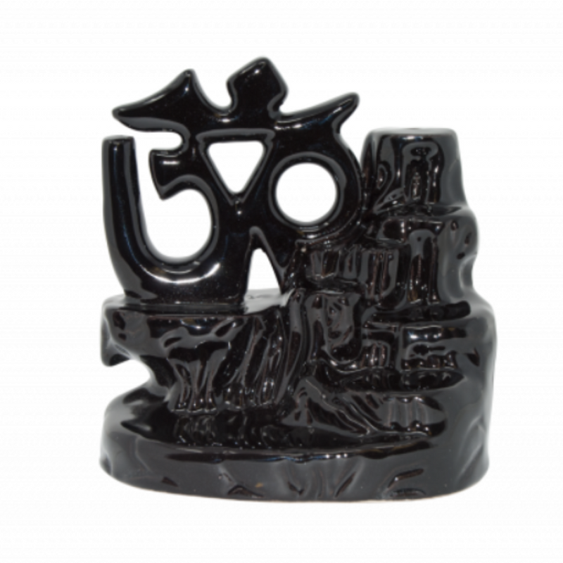 Glossy ceramic Om-shaped backflow incense burner producing a meditative smoke waterfall—used to enhance presence, ritual, and ambient peace.