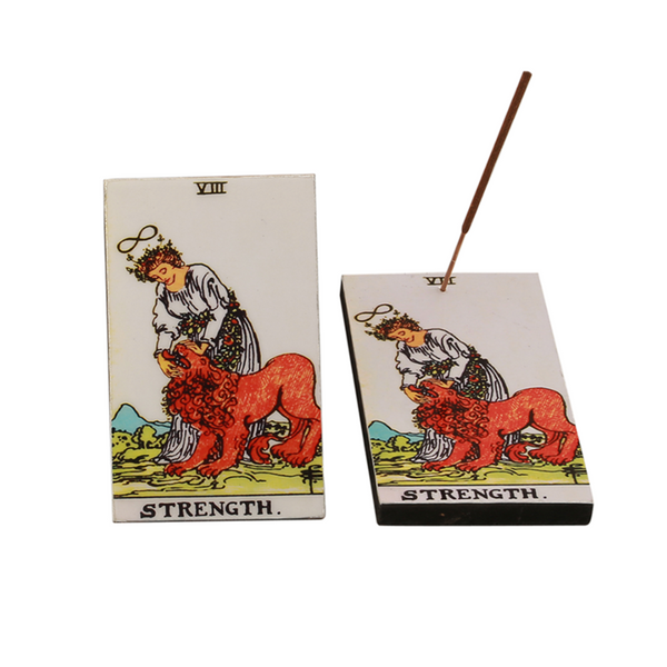 Tarot card incense stick holder with 'Strength' card design, showing a woman and a lion, placed on a white background.