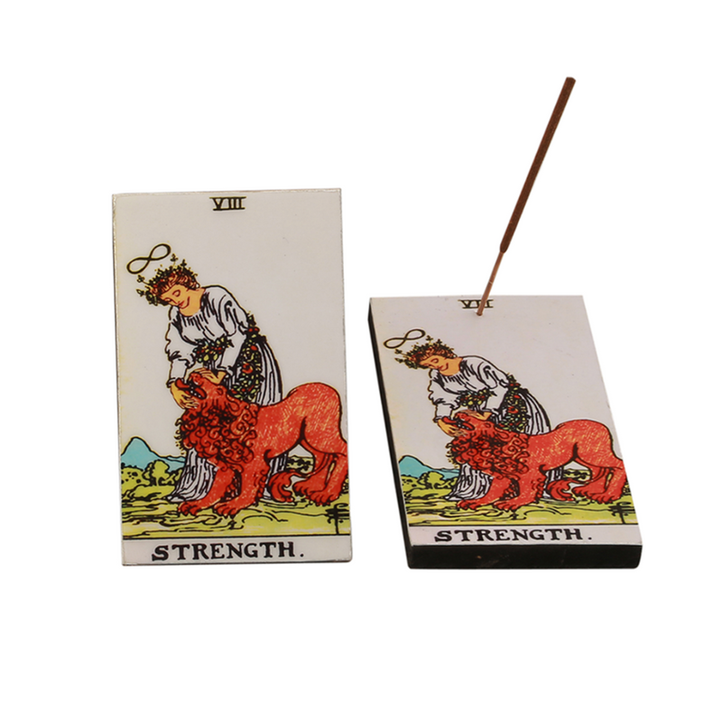 Tarot card incense stick holder with 'Strength' card design, showing a woman and a lion, placed on a white background.