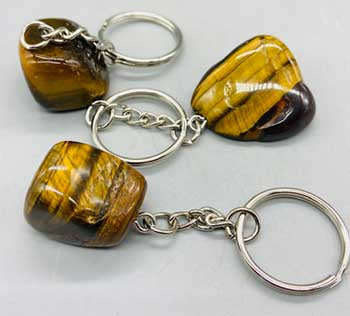 A set of three Tiger Eye keychains with silver metal rings and chains, showcasing the golden-brown colored gemstones.