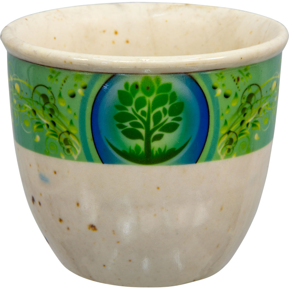 A small beige ceramic smudge pot with a green and blue floral pattern featuring a Tree of Life design.